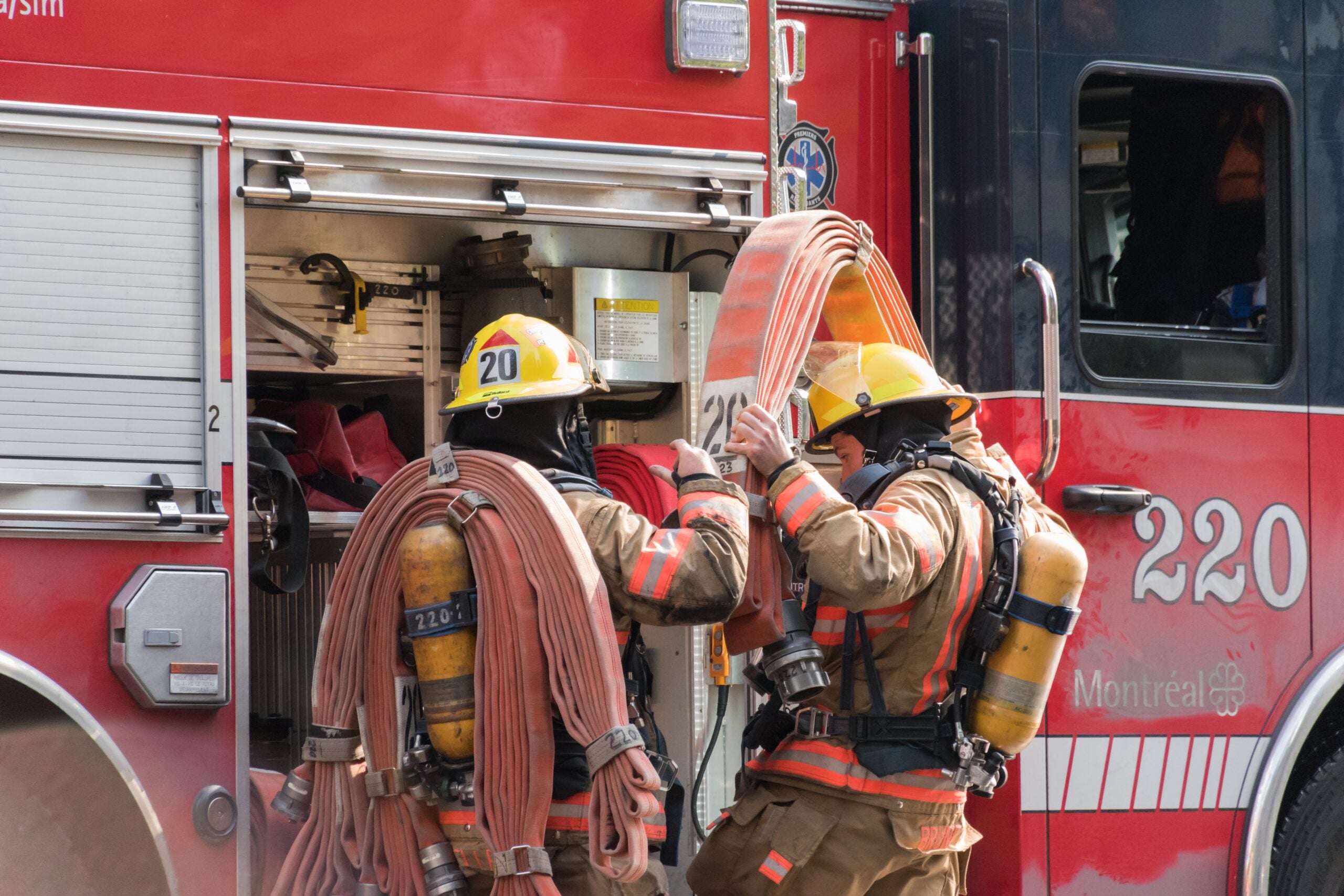 Firefighters preparing hoses at a fire truck, showcasing teamwork in emergency response, relevant to family law support for frontline workers in Hammond, Indiana.