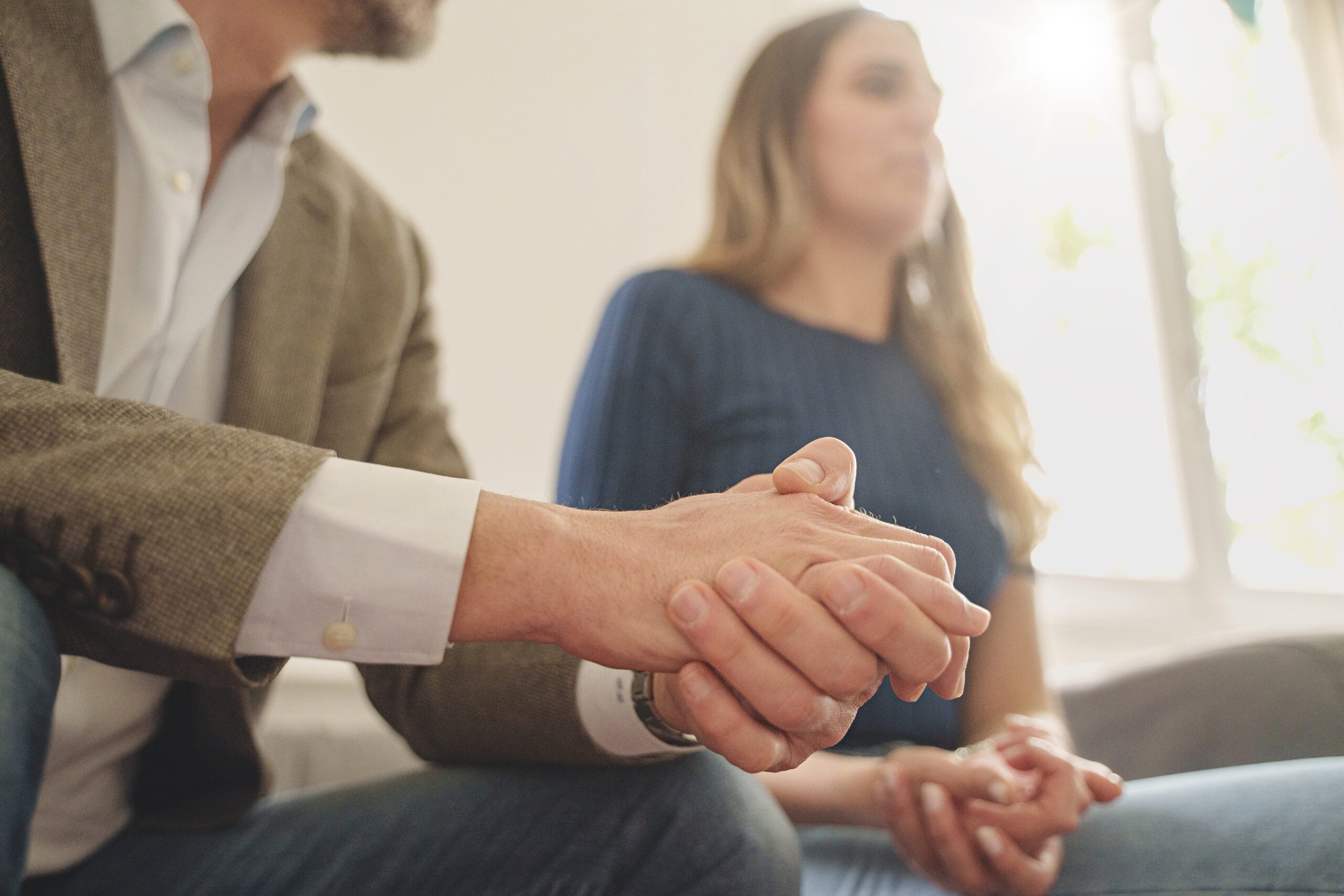 Embarrassed couple sitting in a family therapy session, highlighting emotional tension and communication challenges in divorce discussions.