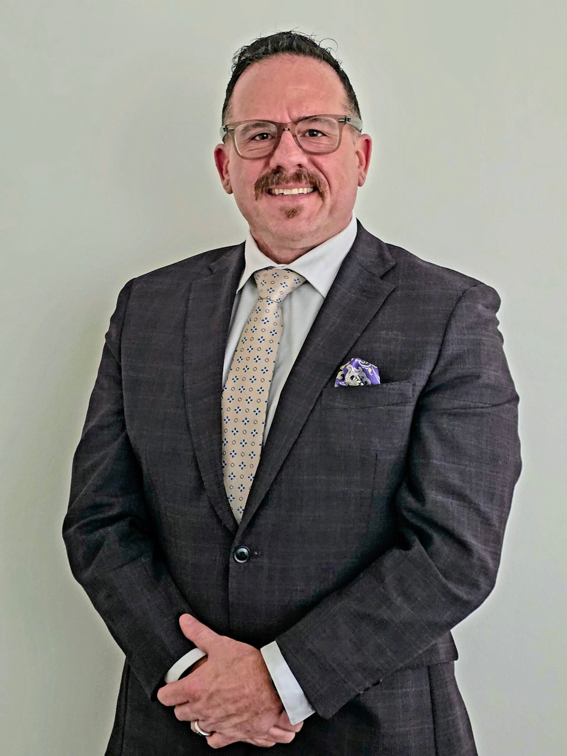 Headshot of Timothy Battistelli, founder of First Response Legal, in a suit and tie, smiling confidently against a plain background, representing expertise in family law and guardianship.