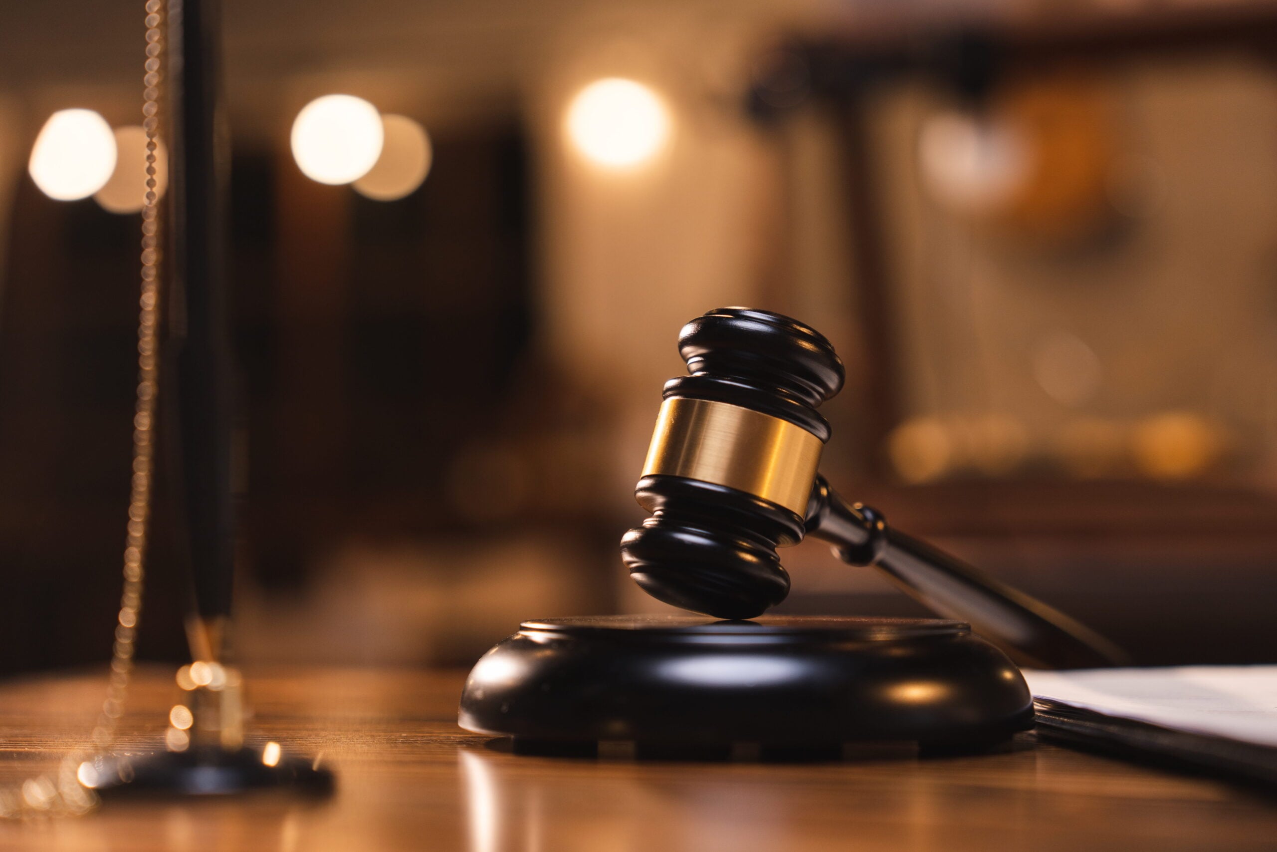 Gavel on a wooden table with blurred legal books in the background, symbolizing legal representation and misdemeanor defense services in Northwest Indiana and the Chicagoland area.