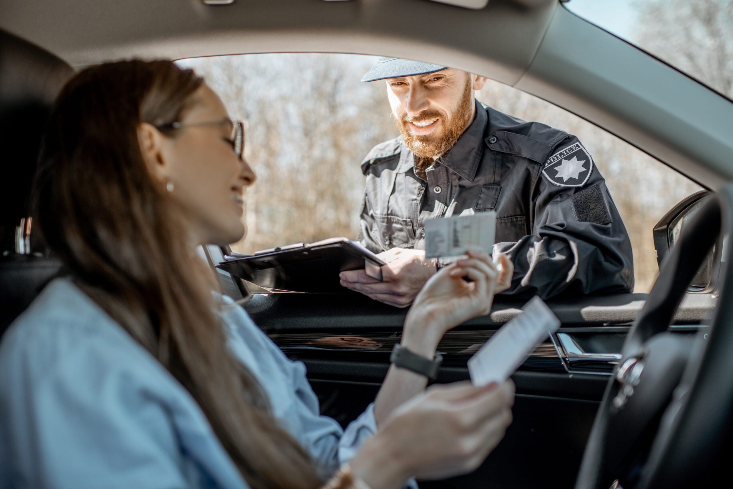 Police officer checking documents of a female driver during a traffic stop, emphasizing legal guidance for traffic violations in Northwest Indiana.